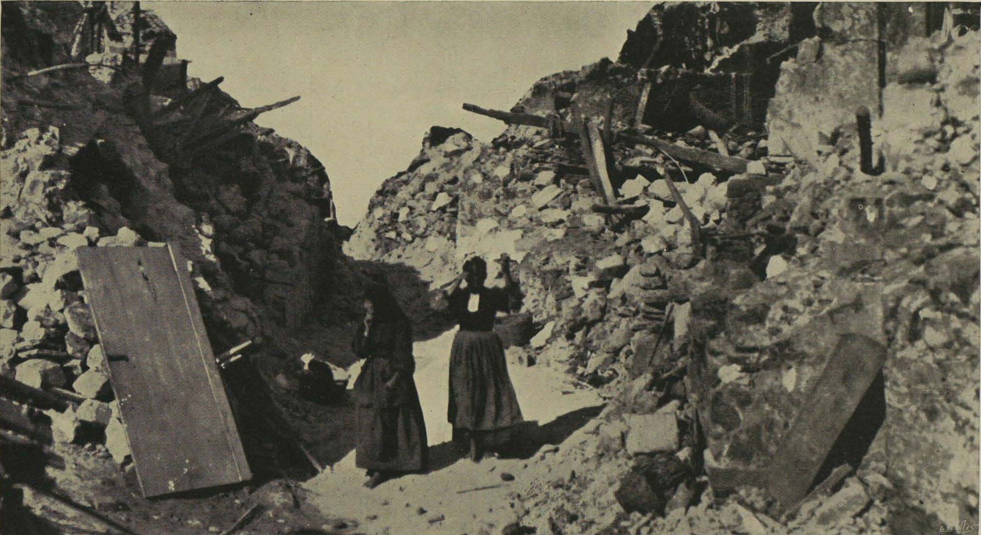 Homeless women standing in the ruins of where their houses once stood.