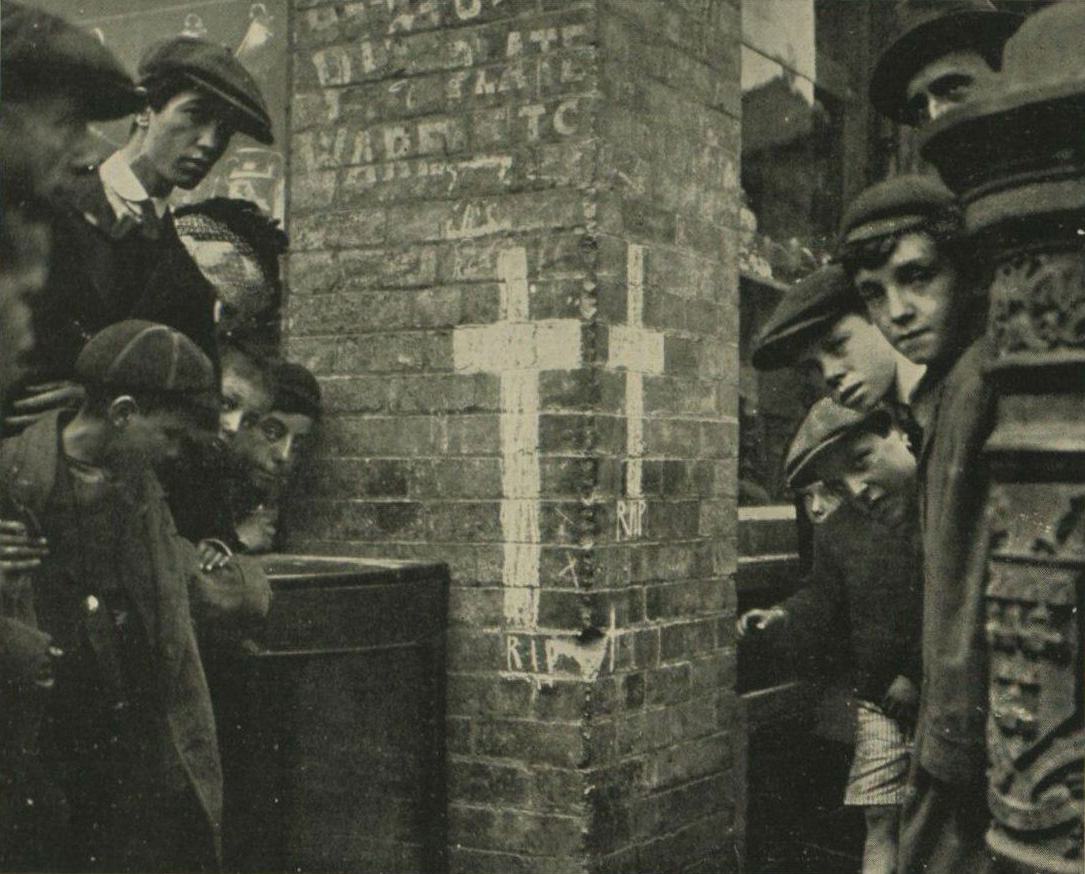 People standing on the corner of Liffey Street by a memorial for those who were killed on Bachelors Walk