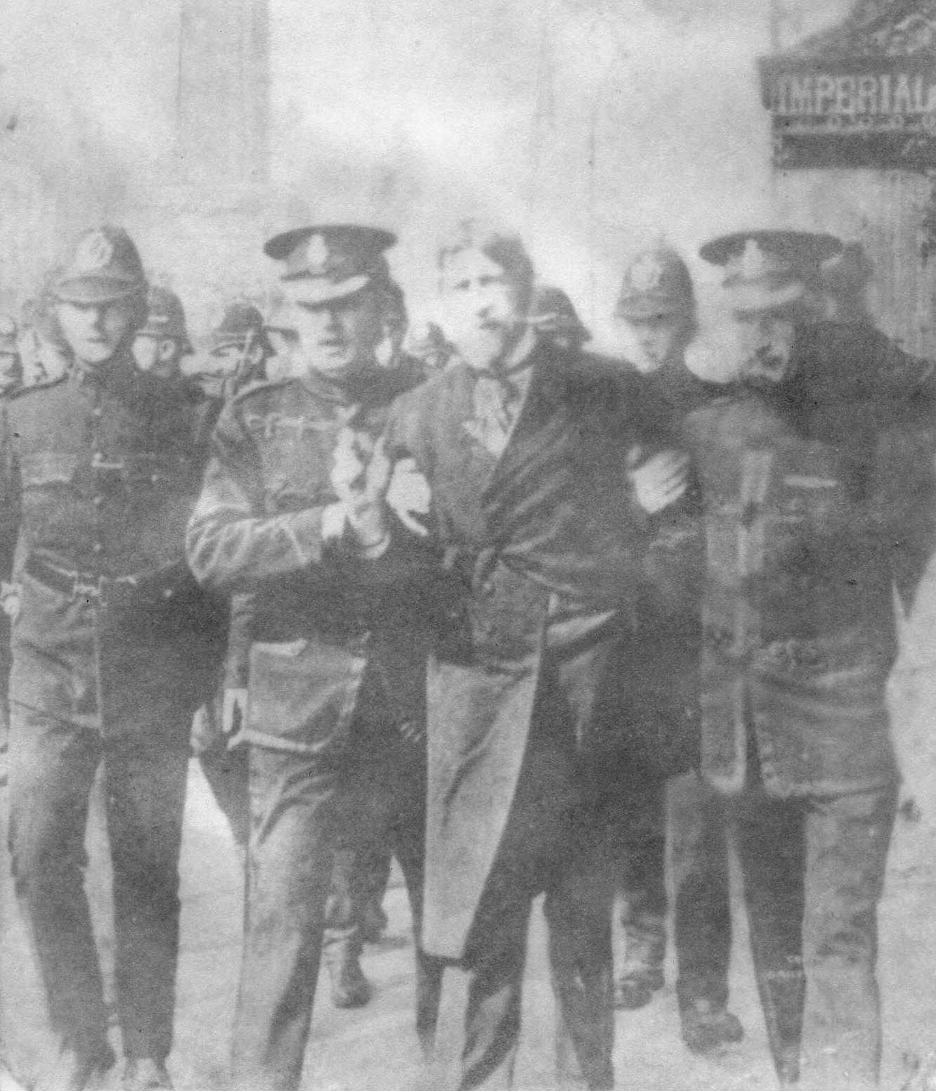 Jim Larkin, still in disguise, being led away by police outside the Imperial Hotel